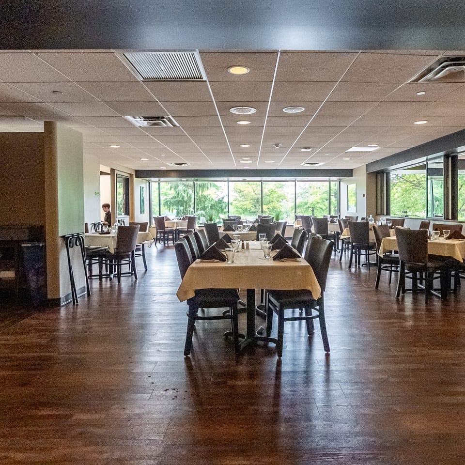 Cucina Vitale dining room with set tables and large windows.